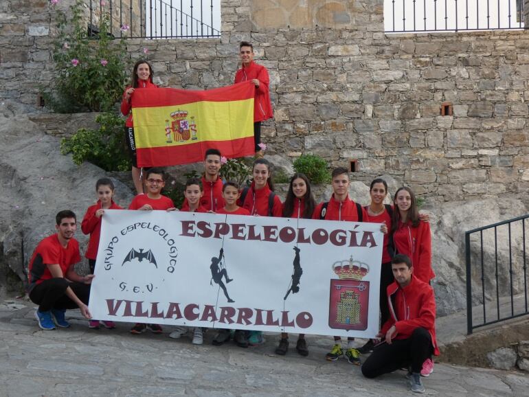 Varios componentes del Grupo de Espeleología de Villacarrillo posando con una bandera de España en un campeonato