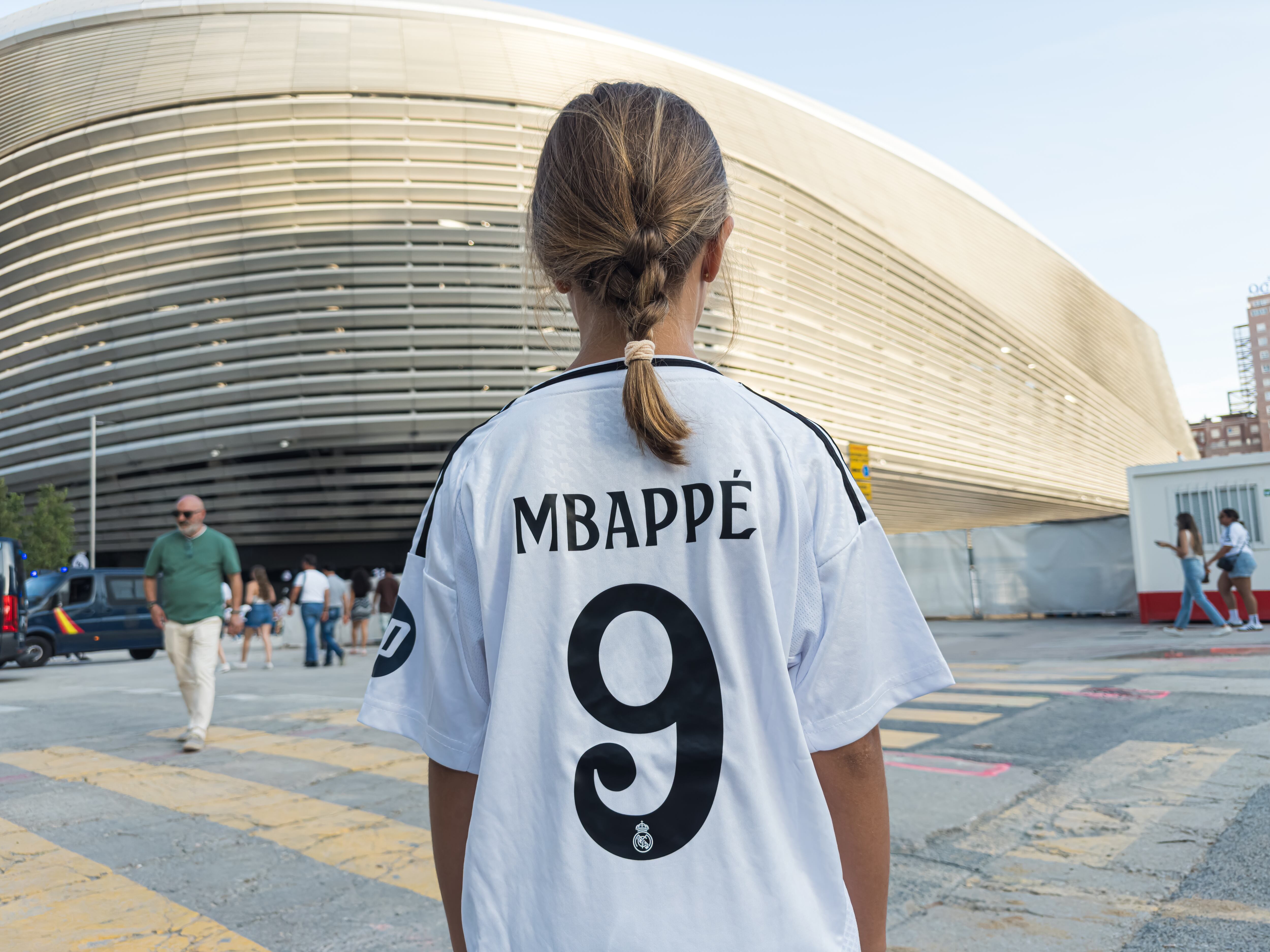Una niña con una camiseta de Mbappé en los aledaños del Bernabéu