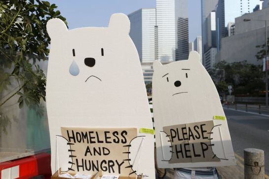 Manifestantes cargan con carteles de osos polares durante la marcha mundial contra el cambio climático en Hong Kong.