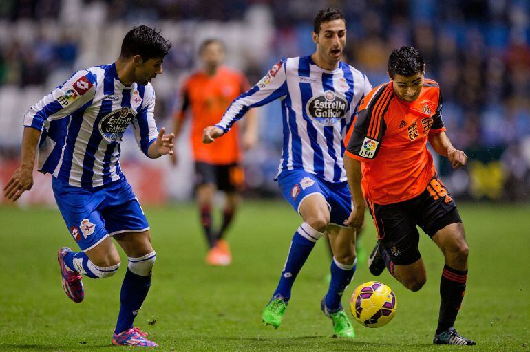 LA CORUNA, SPAIN - NOVEMBER 22: Chory Castro (R) Real Sociedad de Futbol competes for the ball with Luisinho Correia (2ndR) of RC Deportivo La Coruna and his teammate Juanfran Moreno (L) teammate during the La Liga match between RC Deportivo La Coruna and