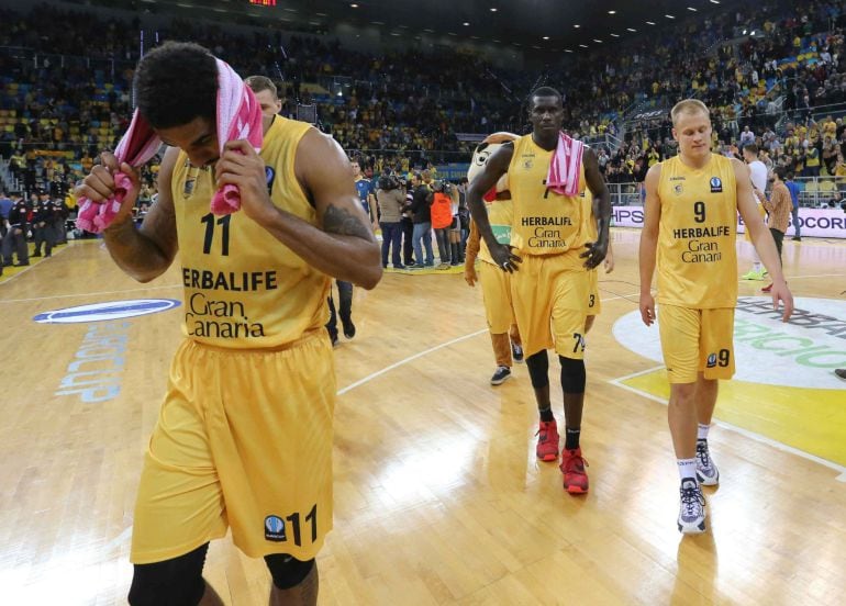 Los jugadores del Herbalife Gran Canaria, DJ Seeley (i), Sitapha Savané (c) y Sasu Salin (d), tras ser eliminados de la competición al finalizar el partido de vuelta de las semifinales de la Eurocopa que Herbalife Gran Canaria y Galatasaray disputaron hoy