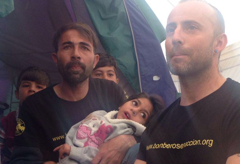 Javier Bodego, de Bomberos en Acción, con Osman y su padre, en el campo de refugiados de Idomeni