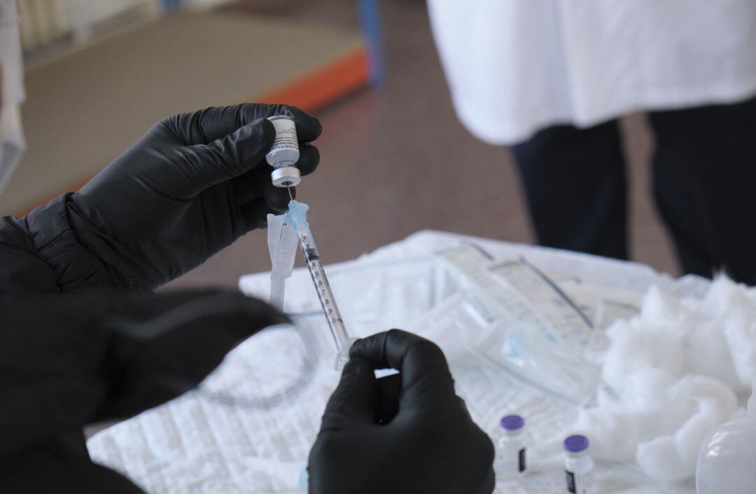 Un trabajador sanitario prepara una de las primeras vacunas de Pfizer-BioNTech