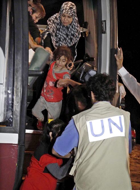 Un empleado de la ONU da la bienvenida a un grupo de refugiados sirios a su llegada al primer campamento para refugiados sirios montado en Jordania