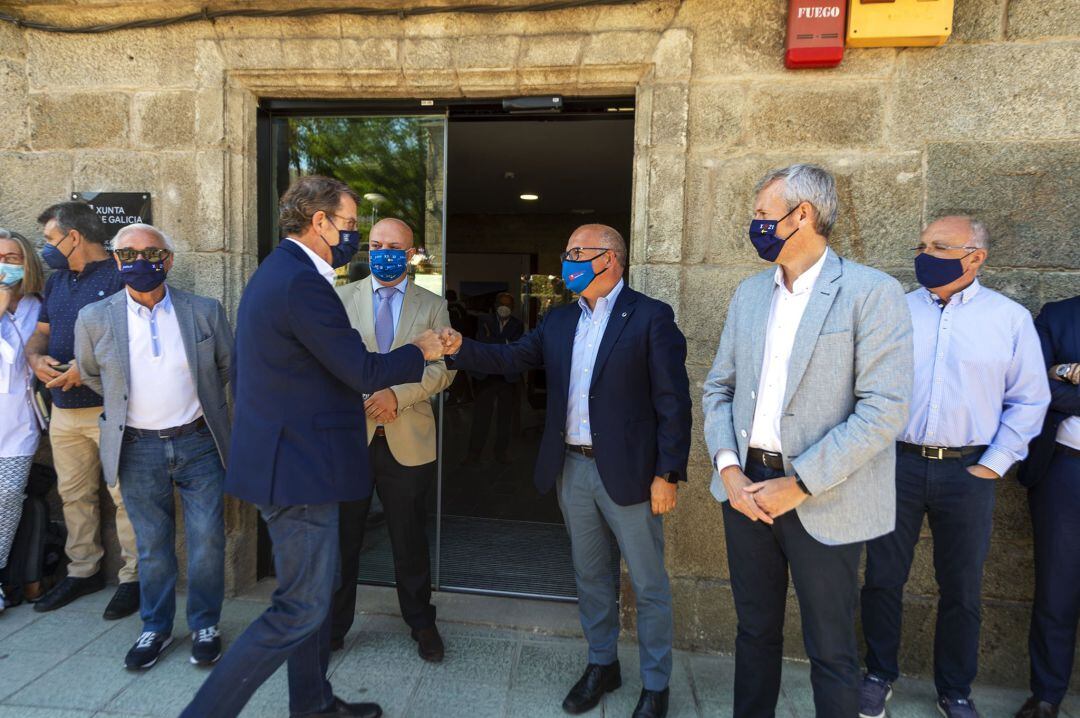 El presidente de la Xunta, Alberto Núñez Feijóo, saluda a Baltar ante la mirada de Alfonso Rueda.