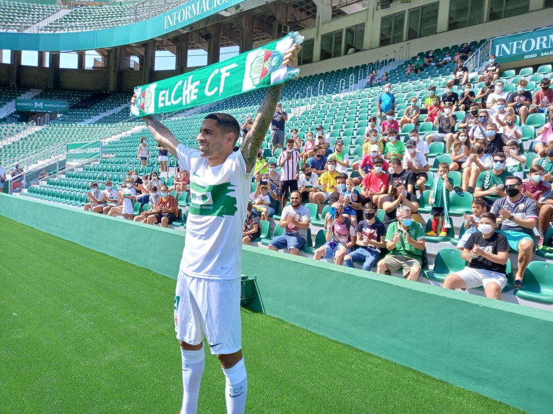 Omar Mascarell posa con una bufanda del Elche junto a los aficionados