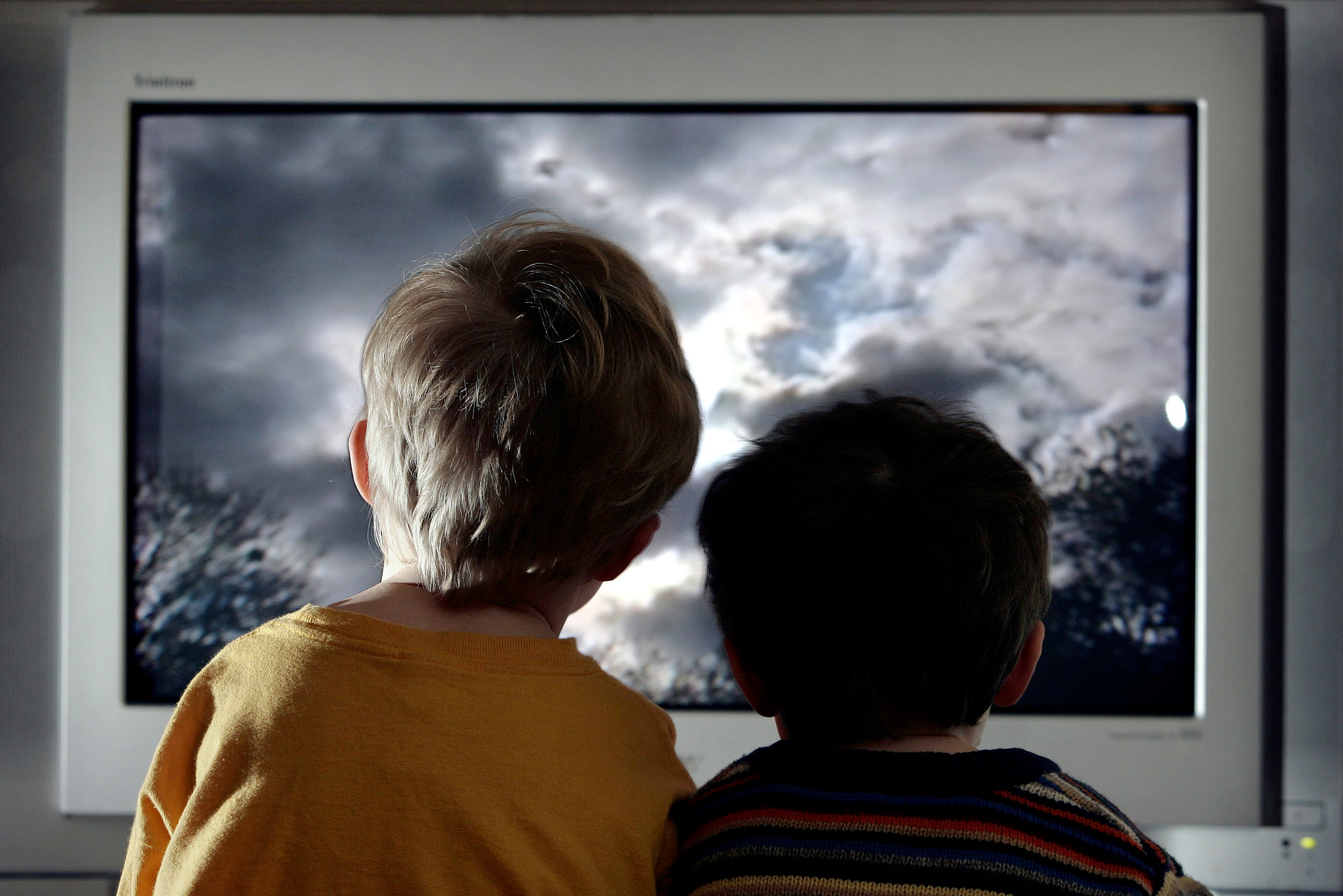 Dos niños viendo la televisión.