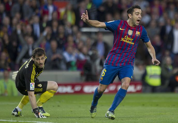 El centrocampista del FC Barcelona Xavi Hernández, junto al portero del Real Madrid, Iker Casillas, durante el partido correspondiente a la trigésimo quinta jornada de Liga en Primera División, disputado este sábado en el Nou Camp de Barcelona