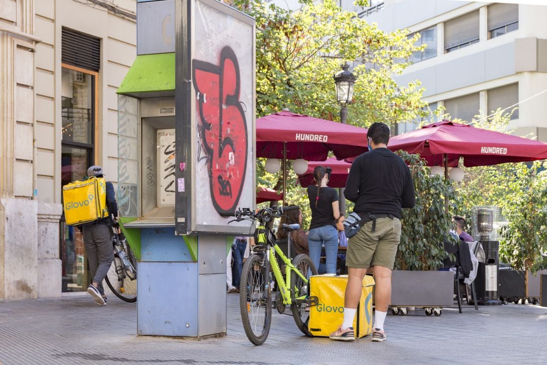 Un repartidor de comida a domicilio de una gran empresa espera a las puertas de un restaurante a recibir un pedido en València.