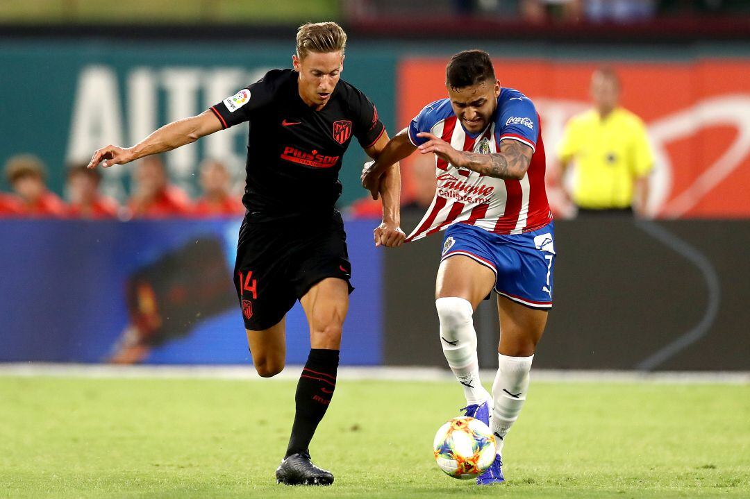 Marcos Llorente disputa un balón ante un jugador del Chivas.