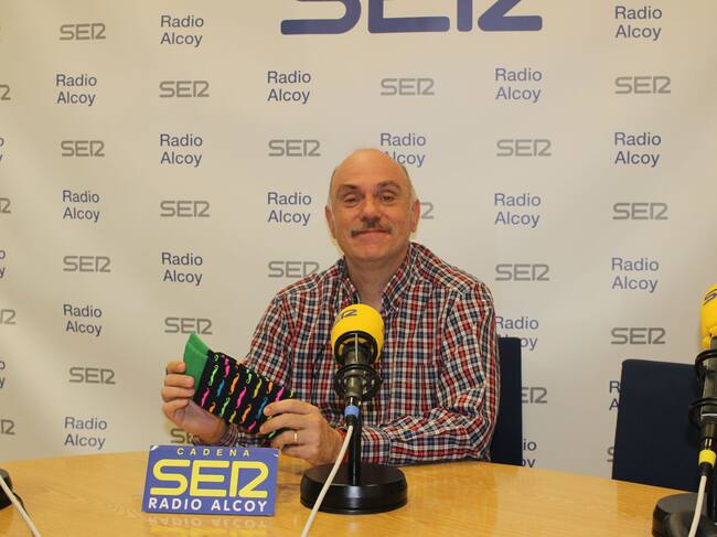 Gabi Barrachina, en el estudio central de Radio Alcoy, muestra uno de los pares de calcetines que están a la venta por un motivo solidario