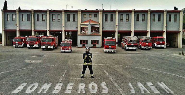 Imagen de un integrante y varios vehículos en el Parque de Bomberos de Jaén capital.