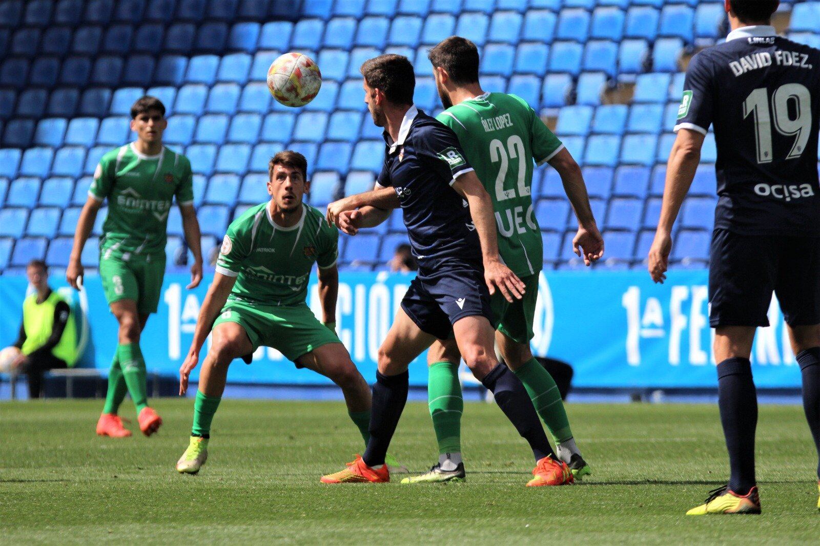 Markel Lozano pugna por un esférico con Álex López ante la mirada de Alfred Planas / UE Cornellà