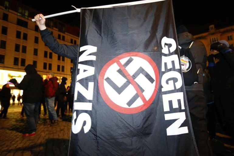 People hold a flag as they protest against the anti-immigrant Alternative for Germany party (AfD) in Dresden, Germany, Sign reads &quot;No nazi&quot;