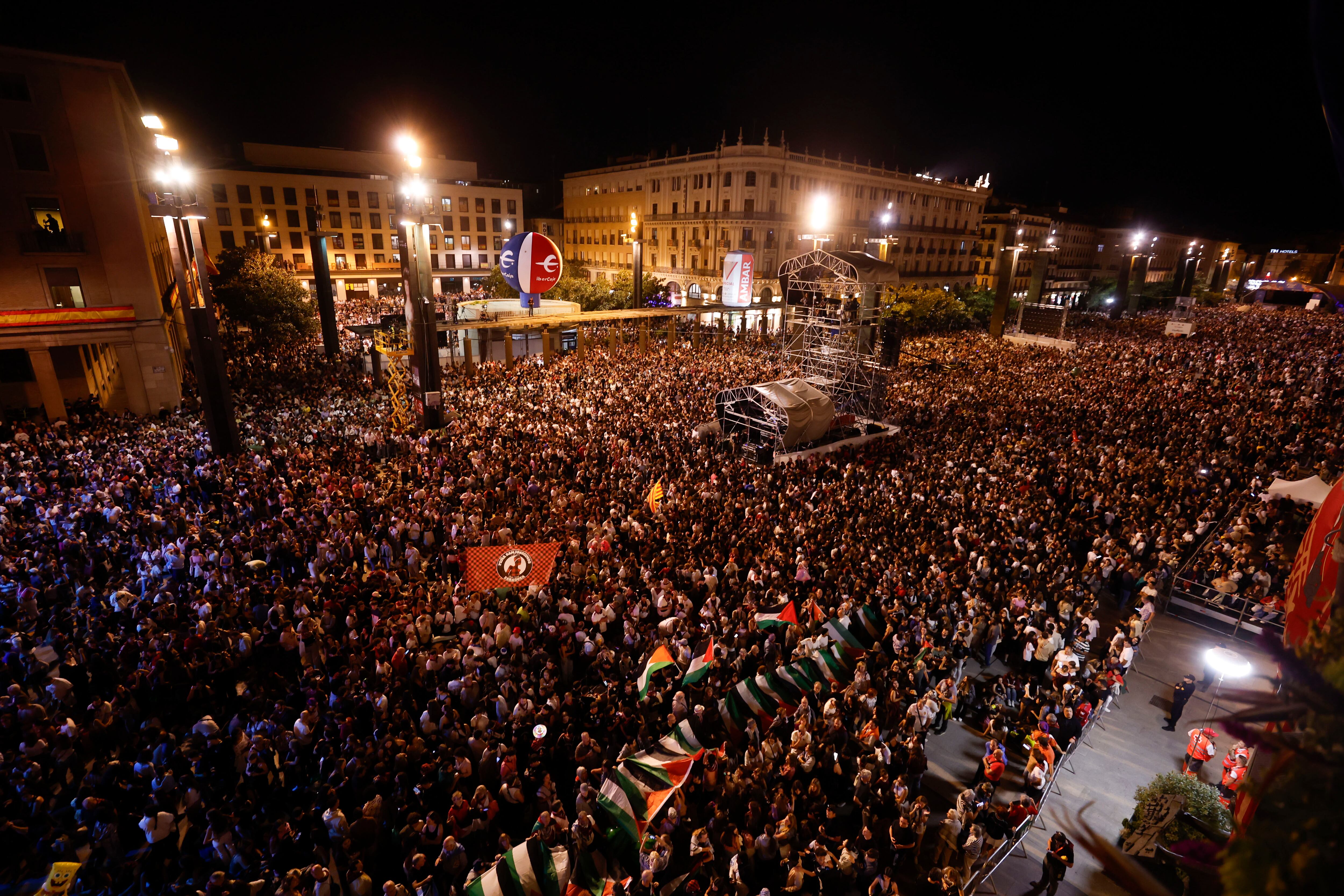 ZARAGOZA, 04/10/2025.- Vista general de la lectura del pregón de inicio de las Fiestas del Pilar 2025 a cargo de los cineastas zaragozanos Javier Macipe, Pilar Palomero y Paula Ortiz, acompañados por la diseñadora de vestuario Arantxa Ezquerro, la realizadora Blanca Torres y el actor Pepe Lorente, y la alcaldesa Natalia Chueca, este sábado en la plaza del Pilar en Zaragoza.- EFE/ Javier Cebollada
