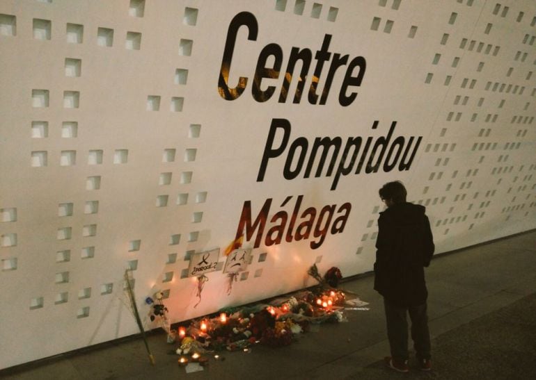 Velas y ramos de flores depositados durante el sábado ante el Centro Pompidou de Málaga en recuerdo a las víctimas de los atentados