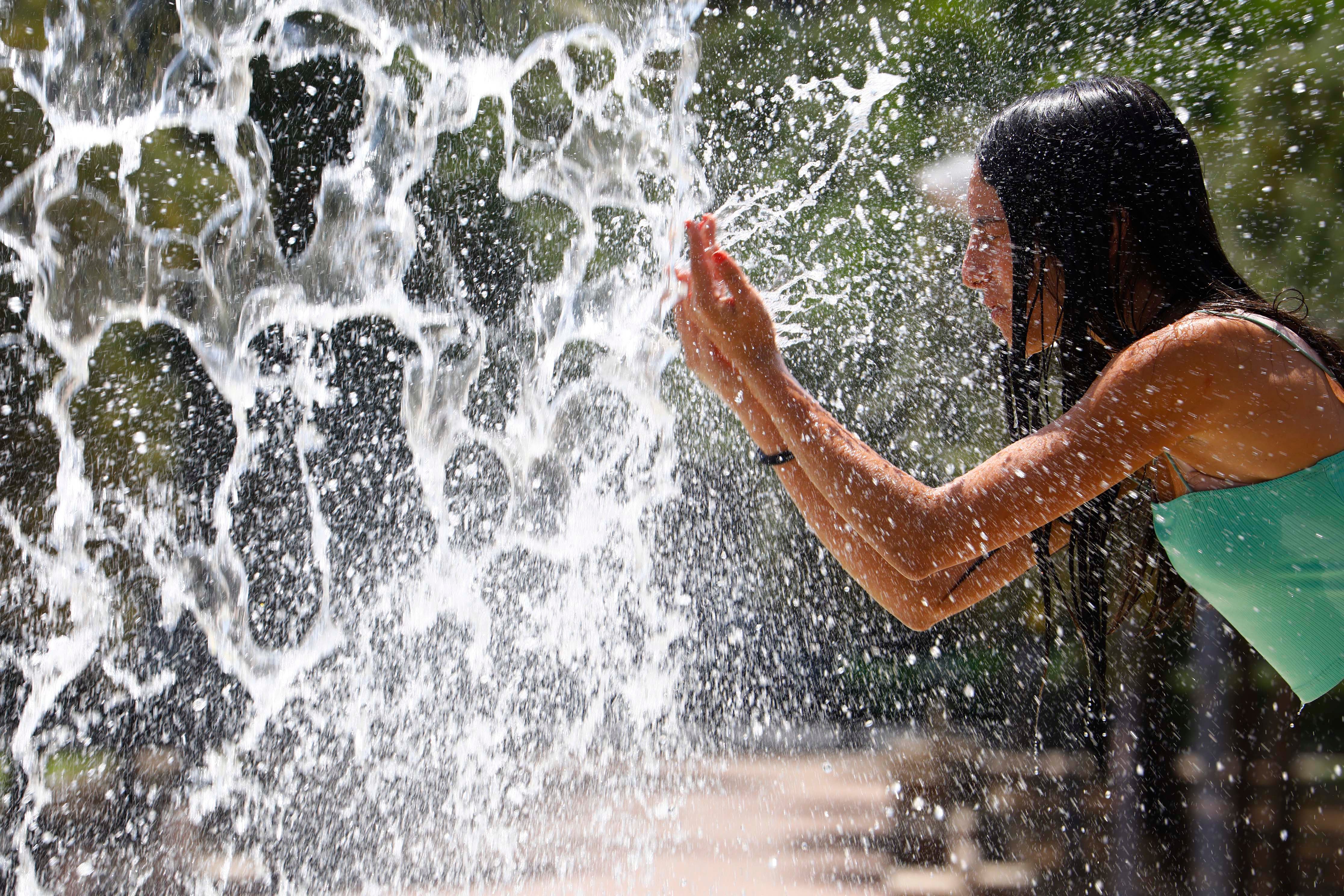 Una persona se refresca en una de las fuentes del centro de Córdoba este domingo