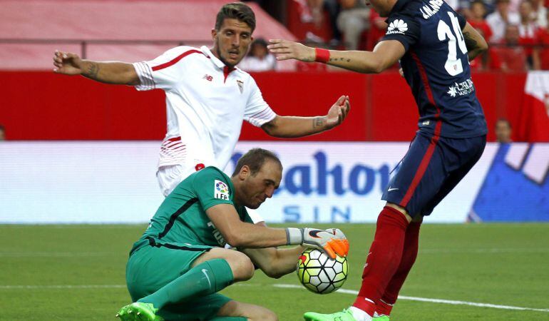 GRA240. SEVILLA. 30/08/2015.- El defensa portugués del Sevilla FC Danisl Carriço (i) presiona a los jugadores del Atlético de Madrid, el portero esloveno Jan Oblak (c ) y el uruguayo José María Giménez (d), durante el partido de la segunda jornada de Liga en Primera División que se disputa hoy en el estadio Ramón Sánchez Pizjuán, en Sevilla. EFE/PACO PUENTES