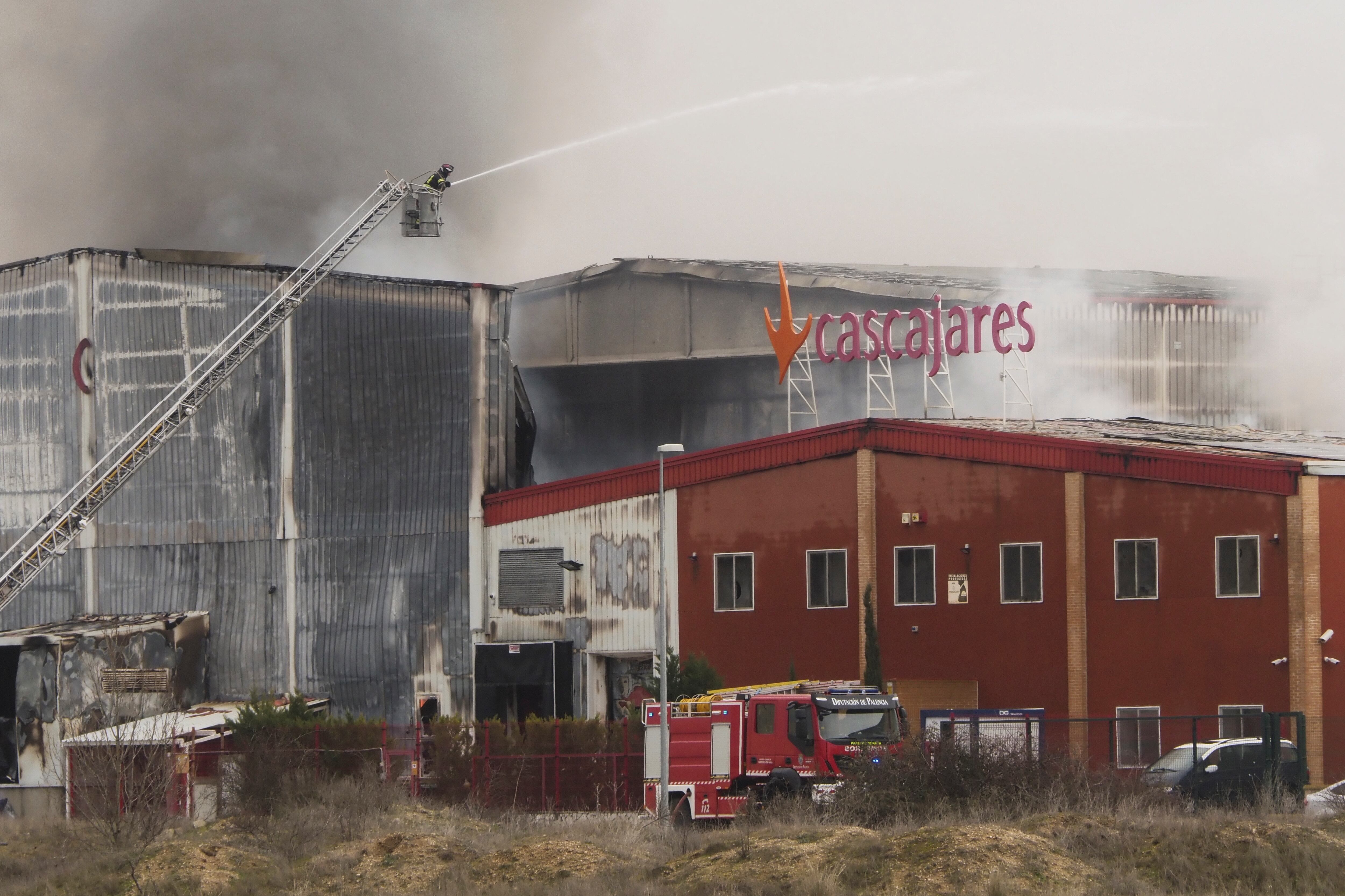 DUEÑAS (PALENCIA), 26/01/2023.- Los bomberos se afanan en apagar el incendio declarado sobre las 3 de la mañana del 26 de enero  en la fábrica de la empresa Cascajares en Dueñas (Palencia) que ha calcinado por completo las dos naves y es una &quot;auténtica catástrofe&quot; para esta compañía, conocida especialmente por sus capones navideños. EFE/ R. Garcia