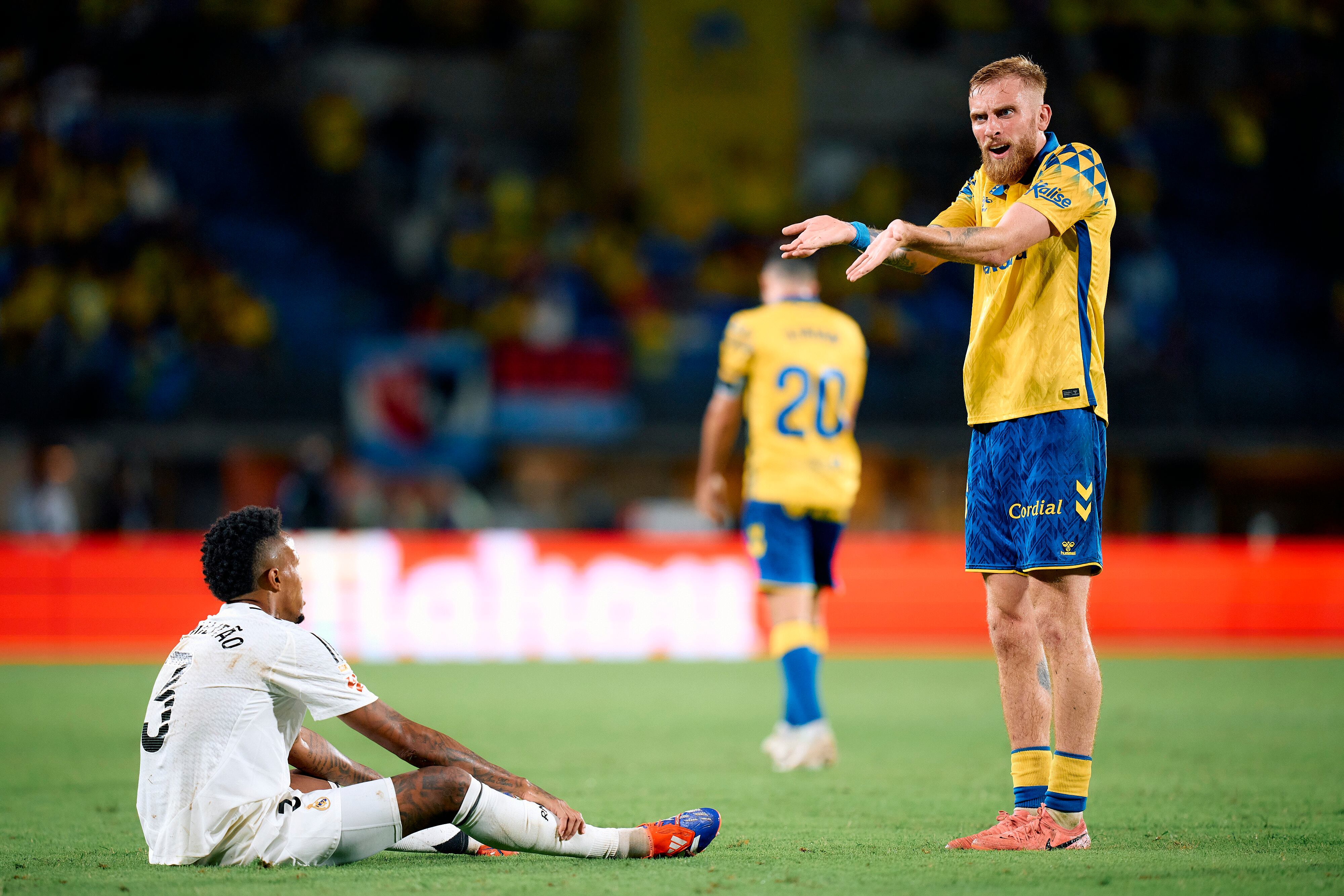 Mcburnie cuestionando una decisión mientras Militao está en el suelo