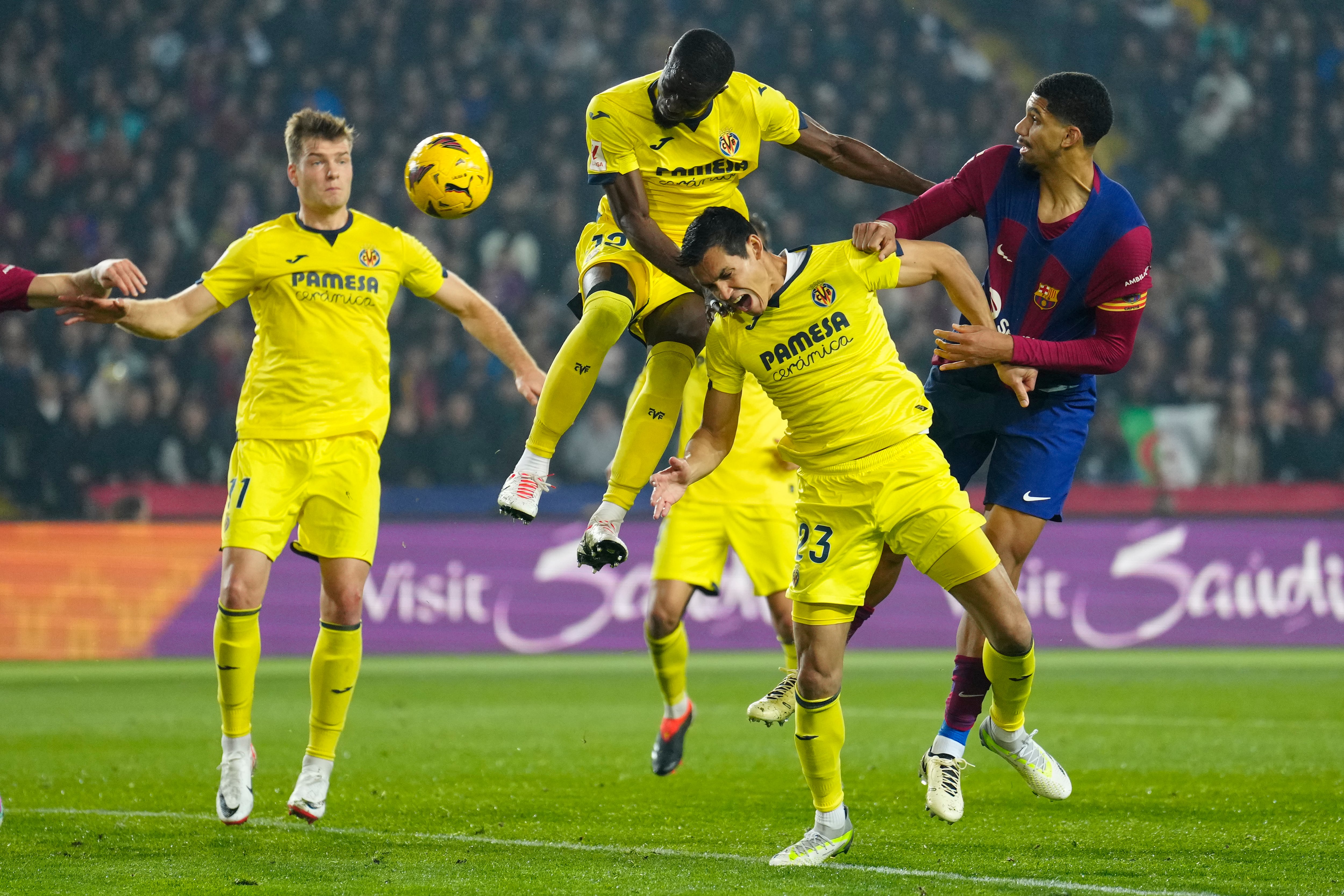 BARCELONA, 27/01/2024.- El defensa uruguayo del FC Barcelona Ronald Araújo (d) salta por el balón con Eric Bailly (3d), del Villarreal, durante el partido de la jornada 22 de LaLiga EA Sports entre el FC Barcelona y el Villarreal CF, este sábado en el estadio Olímpico de Montjuic, en Barcelona. EFE/Enric Fontcuberta
