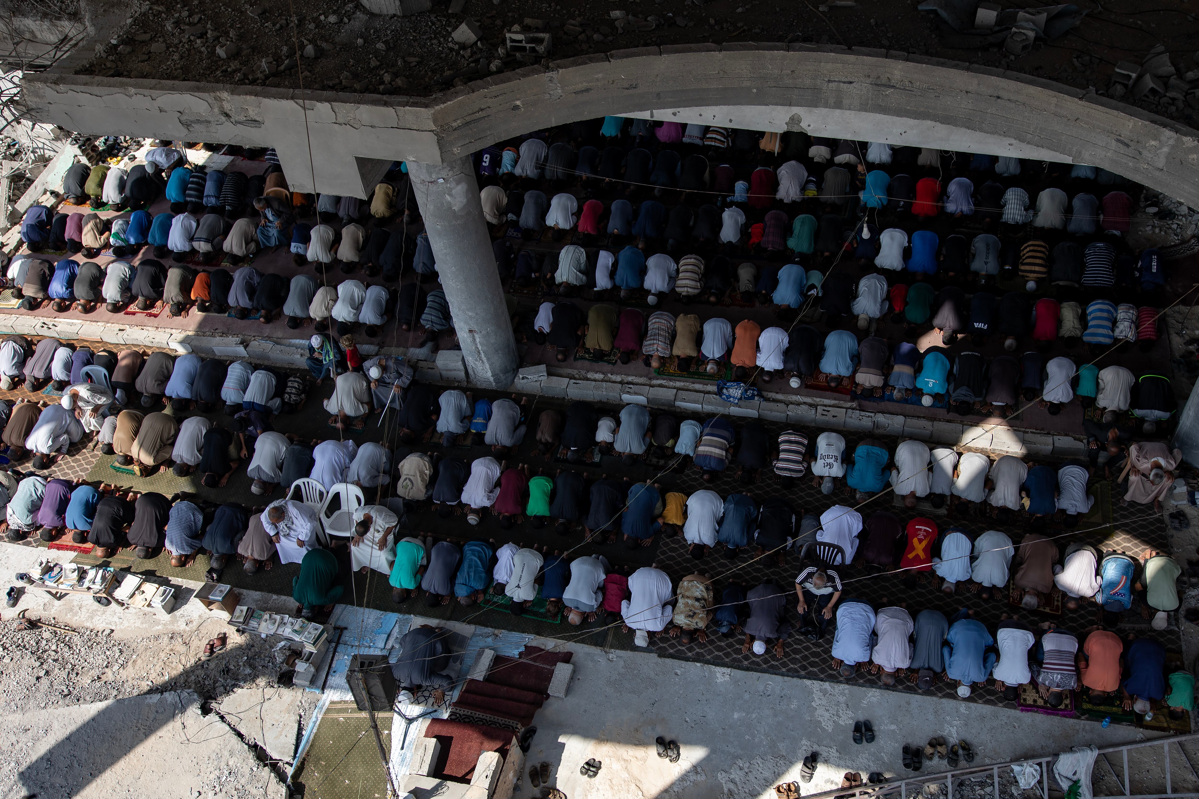Los palestinos desplazados internos realizan las primeras oraciones del viernes tras el alto el fuego entre Israel y Hamás entre las ruinas de la mezquita Al-Albani, destruida en el campo de Khan Yunis, al sur de la Franja de Gaza, el 17 de octubre de 2025.