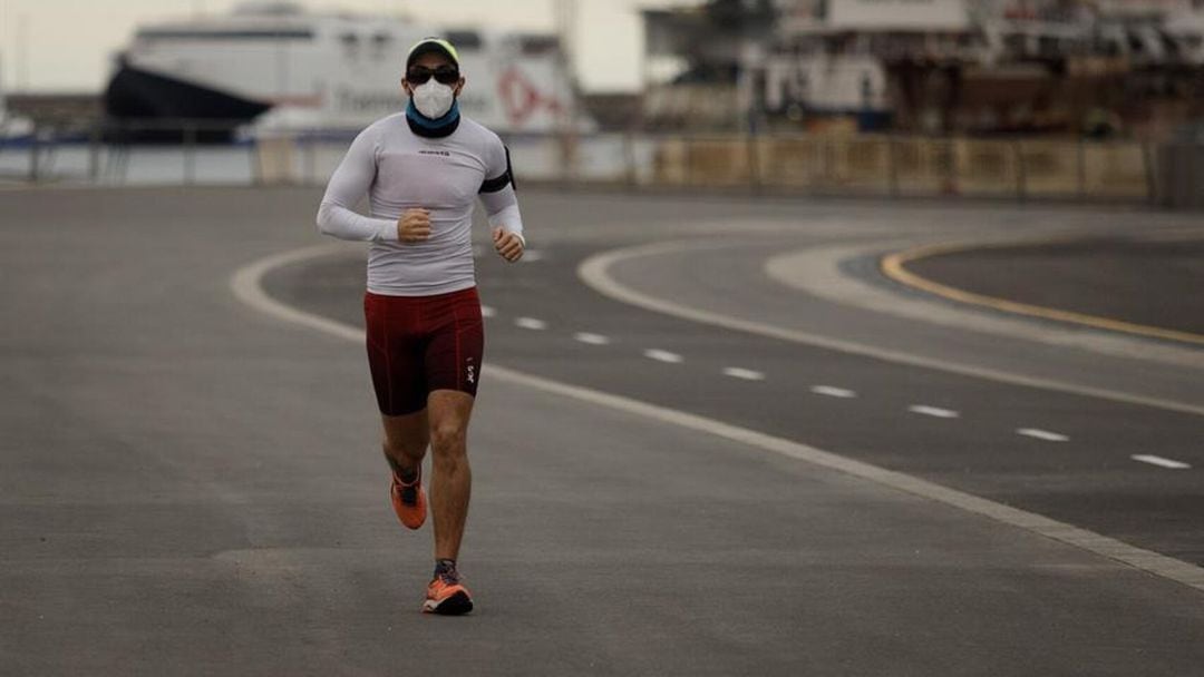 Un corredor haciendo deporte con mascarilla. 
