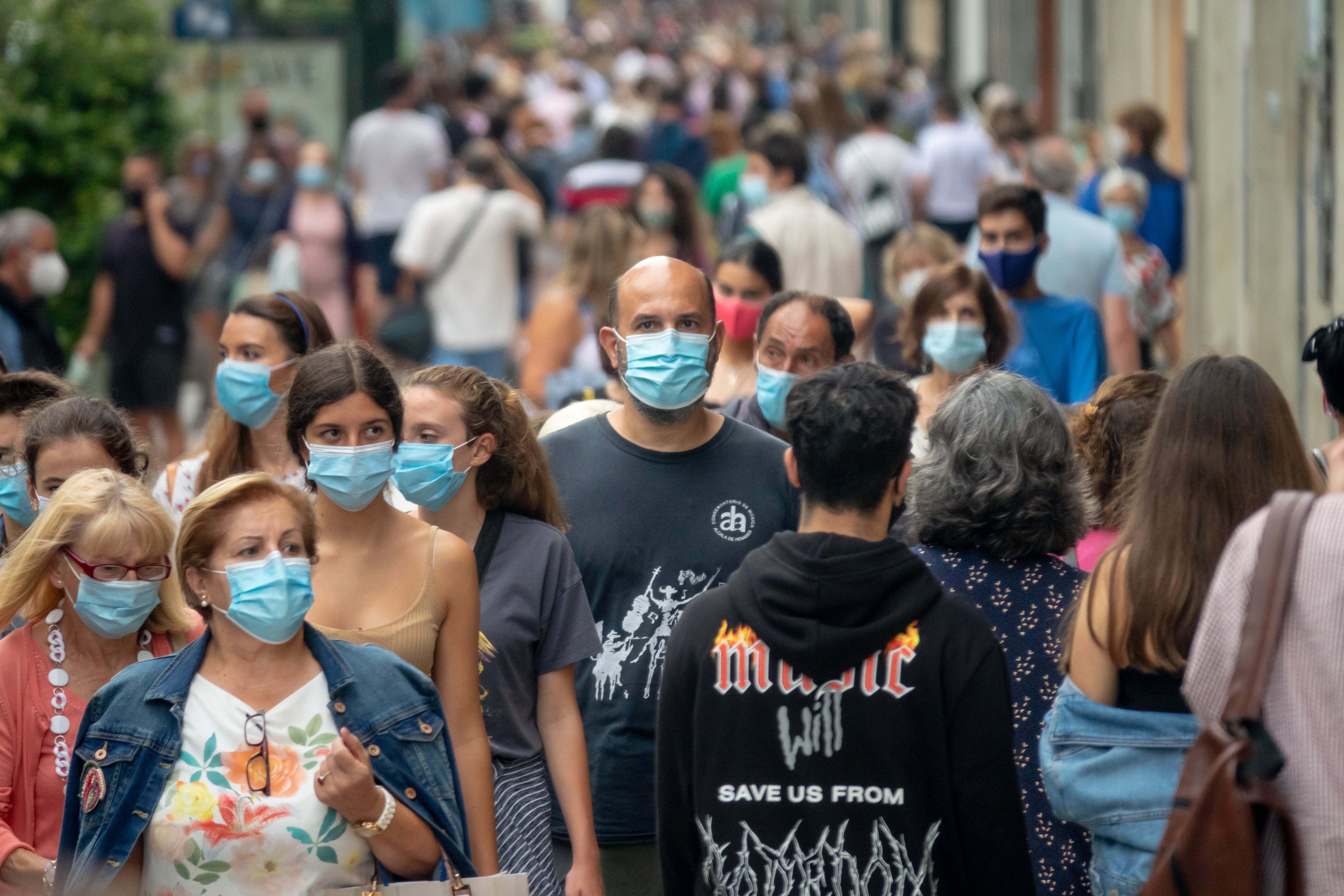Ciudadanos paseando por la calle con la mascarilla puesta.