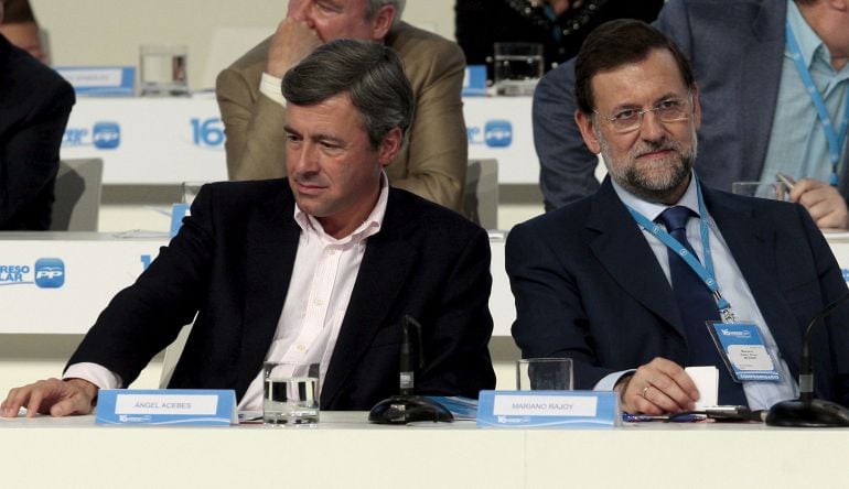 El presidente del PP, Mariano Rajoy (d), conversa con el entonces secretario general saliente del partido, Ángel Acebes (i), durante el XVI Congreso Nacional del PP que se celebró en la Feria de Muestras de Valencia.