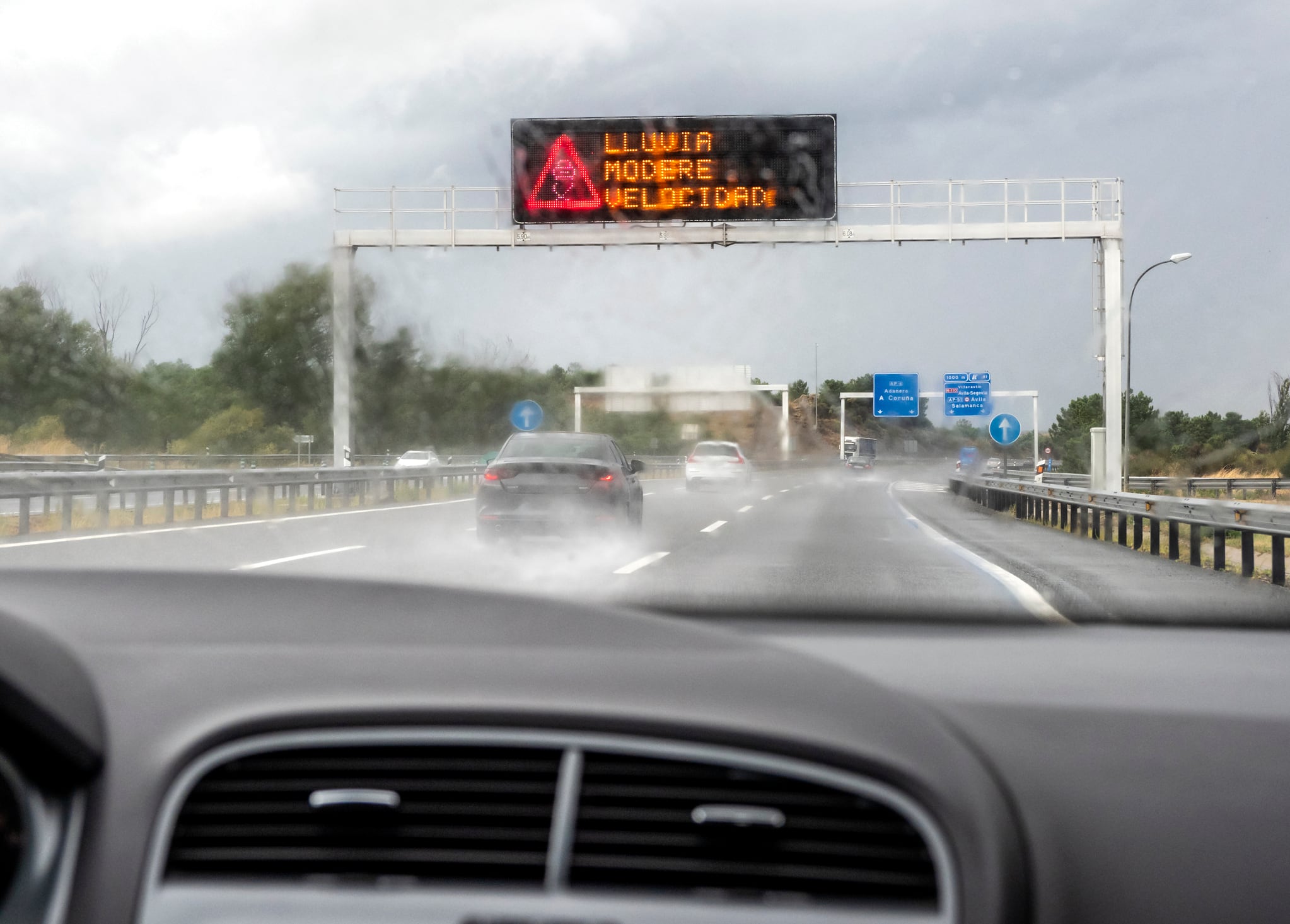 Un coche recorre una carretera bajo la lluvia.