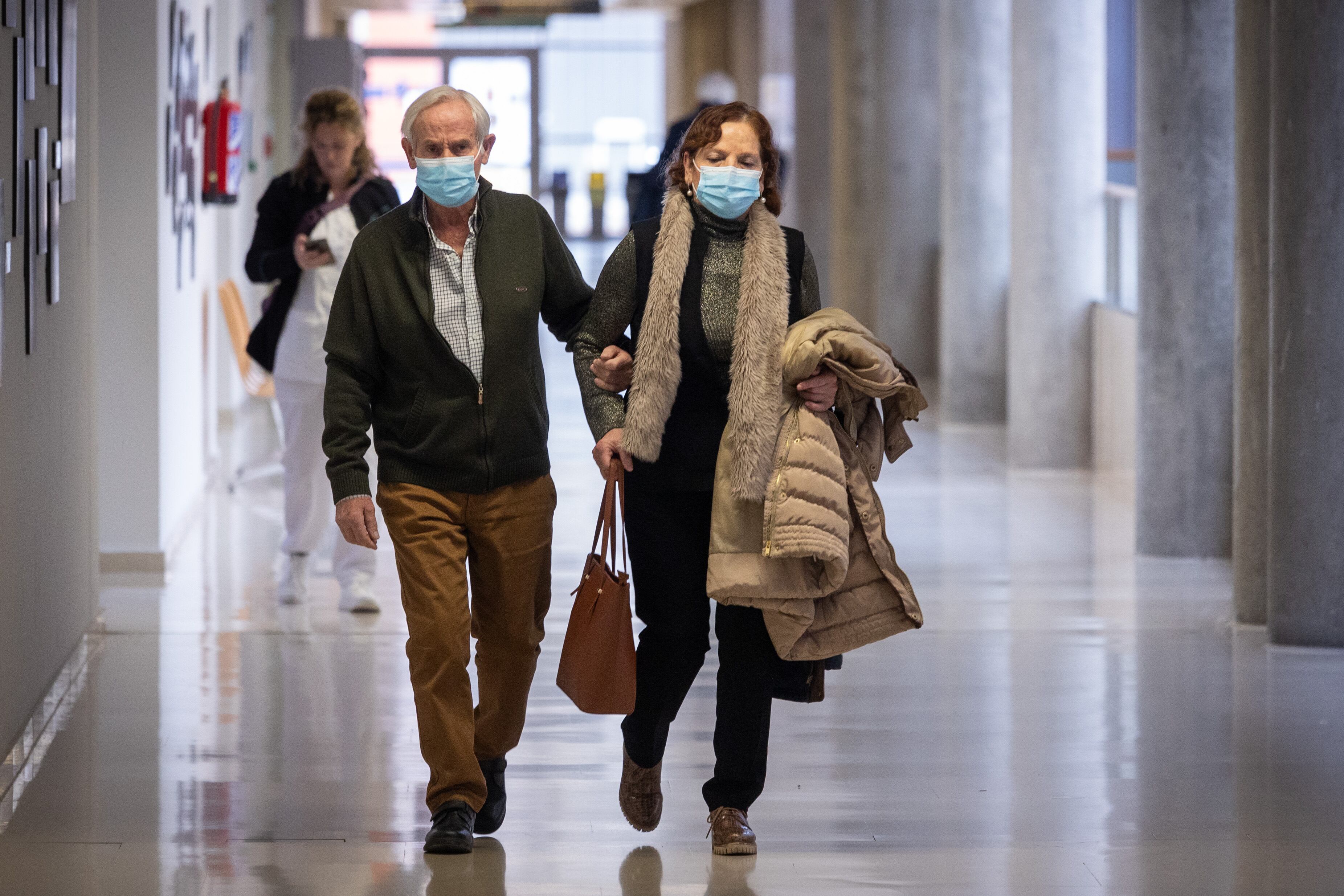 Imagen de archivo de dos personas con mascarilla en un centro sanitario.