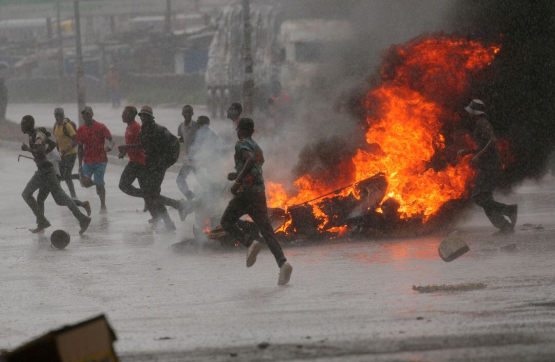  En Harare, Zimbabue, manifestantes corriendo tras incendiar restos y sufrir una carga policial. 