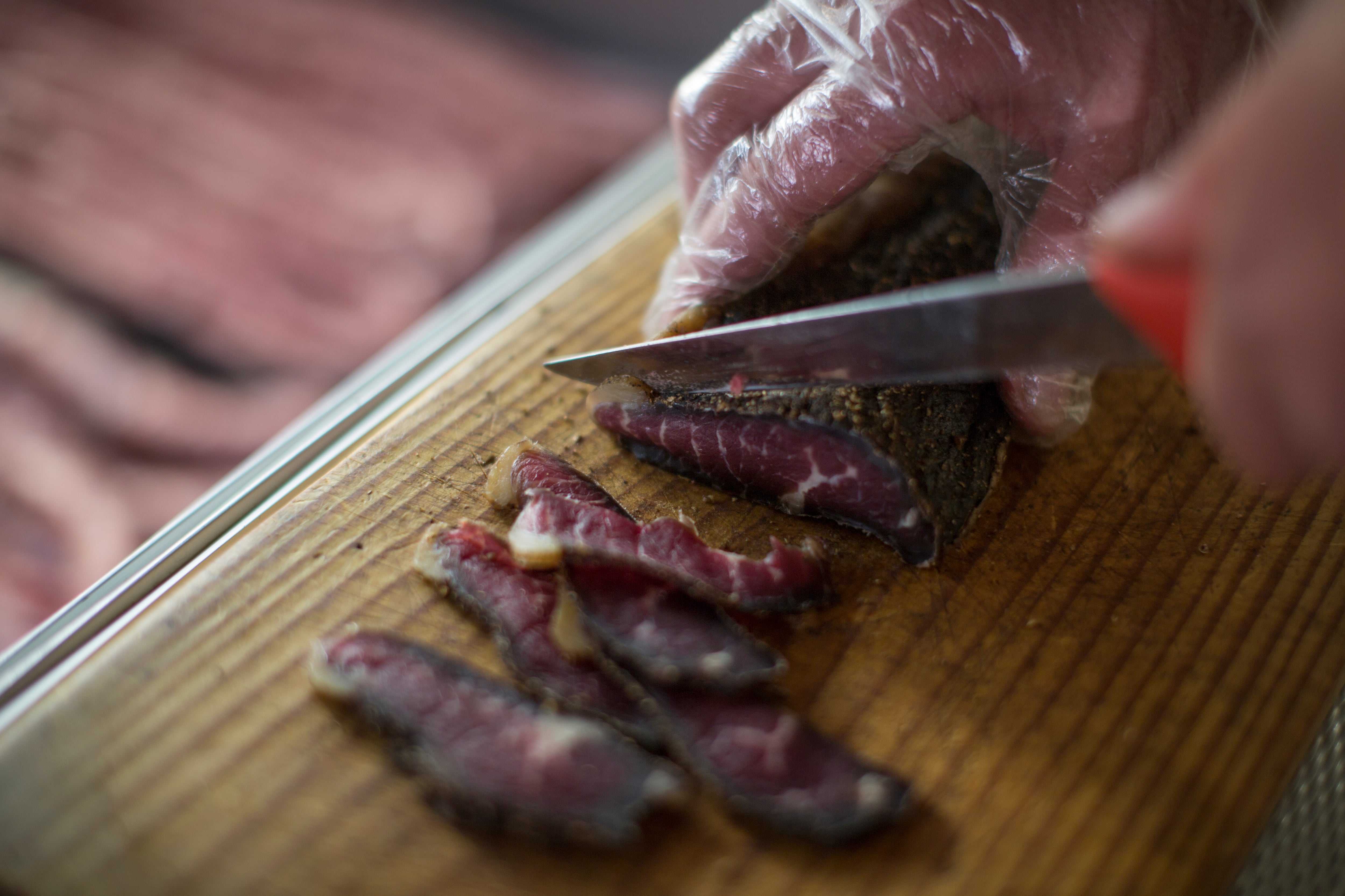 Una persona cortando cecina.