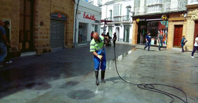 Un operario limpia en centro de Chiclana