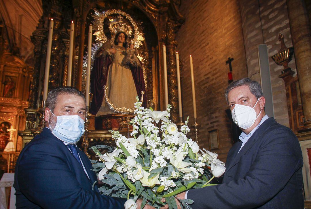 El hermano mayor de la Sagrada Lanzada, Antonio Ramírez Iberburen -a la izquierda de la imagen-, y el presidente del Colegio de Enfermería, José María Rueda, colocan un ramo de flores a las plantas de Ntra. Sra. de la Esperanza Divina Enfermera