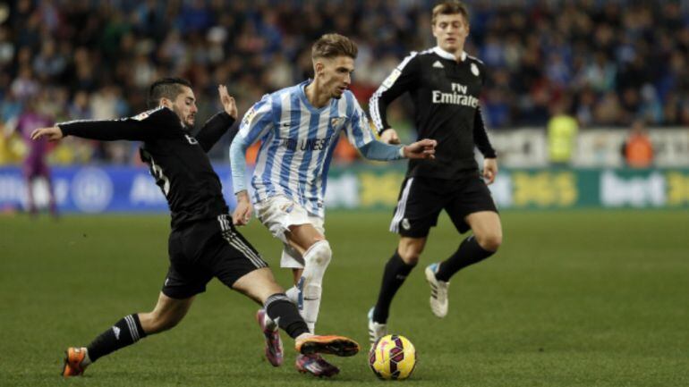 Samu Castillejo ante dos jugadores del Real Madrid