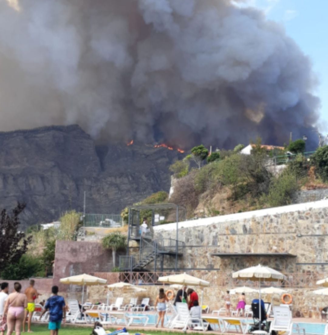 Bañistas miran el fuego en Valleseco, Gran Canaria.