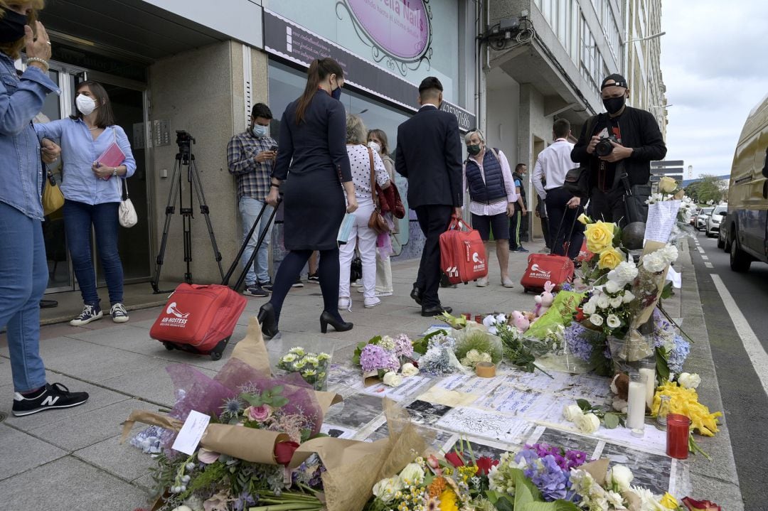 Varias personas pasan al lado del altar colocado en la acera donde fue golpeado Samuel, el joven asesinado en A Coruña el pasado sábado 3 de julio en A Coruña