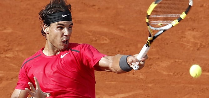 El tenista español Rafael Nadal devuelve una bola al argentino Eduardo Schwank, durante el partido de tercera ronda del Torneo Roland Garros que ambos han disputado en París