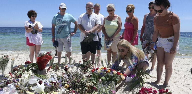 Varios turistas depositan flores en memoria de las víctimas en la playa situada frente al hotel Imperial Marhaba de Susa (Túnez)