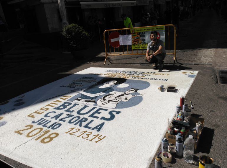 El joven artista Franc Sánchez dibuja el cartel que preside la entrada a la céntrica calle Doctor Muñoz 