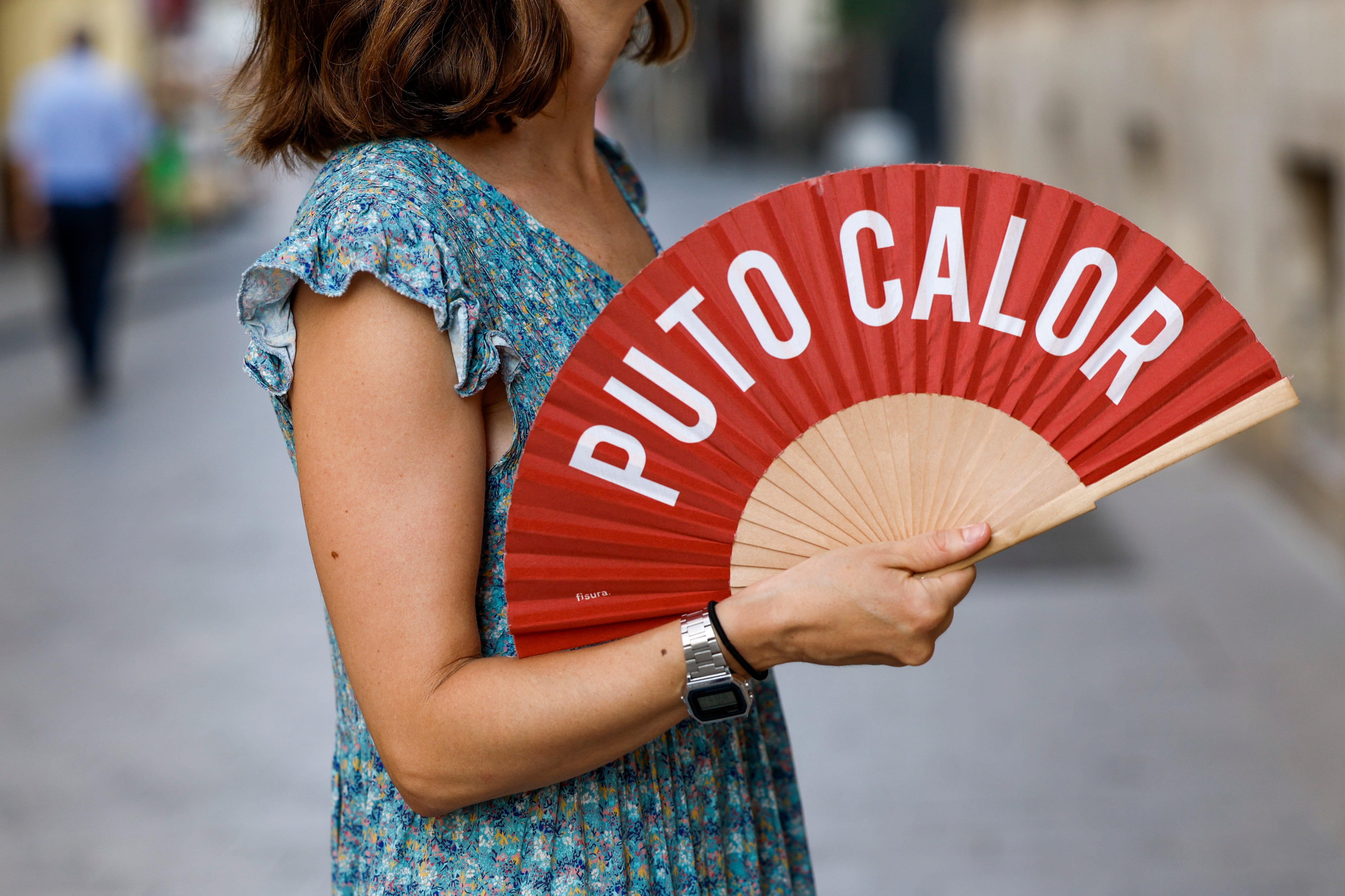 GRAFCVA4658. VALENCIA, 19/07/2023.- Una mujer combate el calor con un abanico cuando, según la Agencia Estatal de Meteorología (Aemet), las temperaturas subirán, las máximas de forma notable en la mitad sur de Alicante, y se alcanzarán valores significativamente elevados en el interior de Castellón, en Valencia y en Alicante, con valores de 42 grados en el extremo sur y de 38-40 en el interior. EFE/Biel Aliño
