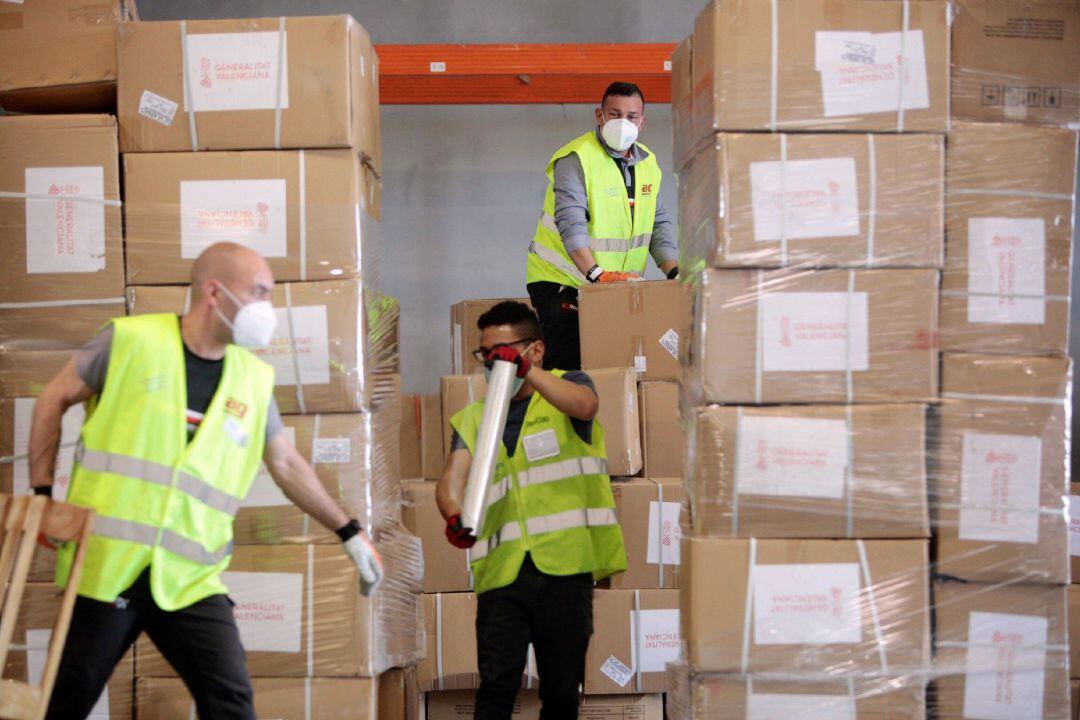 Tres operarios almacenan las 50,8 toneladas de material sanitario que llevaba el décimo cuarto avión con material sanitario de protección fletado por la Generalitat Valenciana y que aterrizó el pasado lunes.
