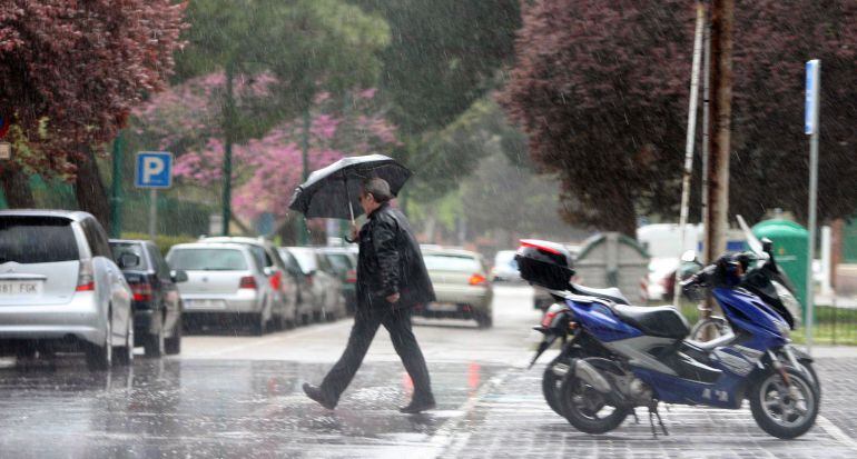 Un hombre se protege de la lluvia bajo un paraguas