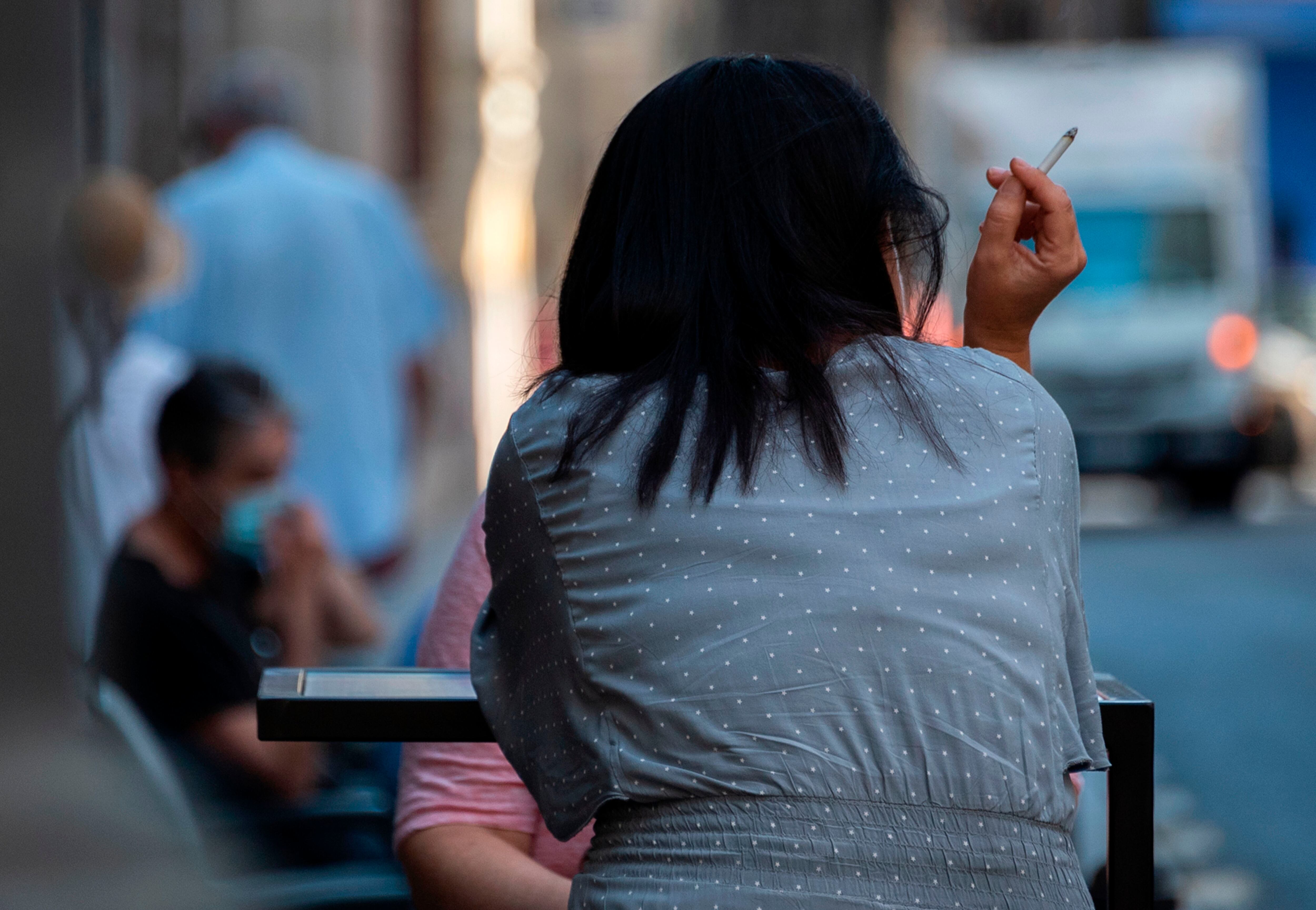 Una mujer fuma en un bar de València, en una imagen de archivo