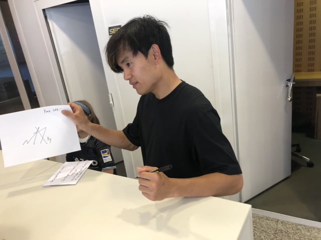 Take Kubo firma un autógrafo a una aficionada de la Real