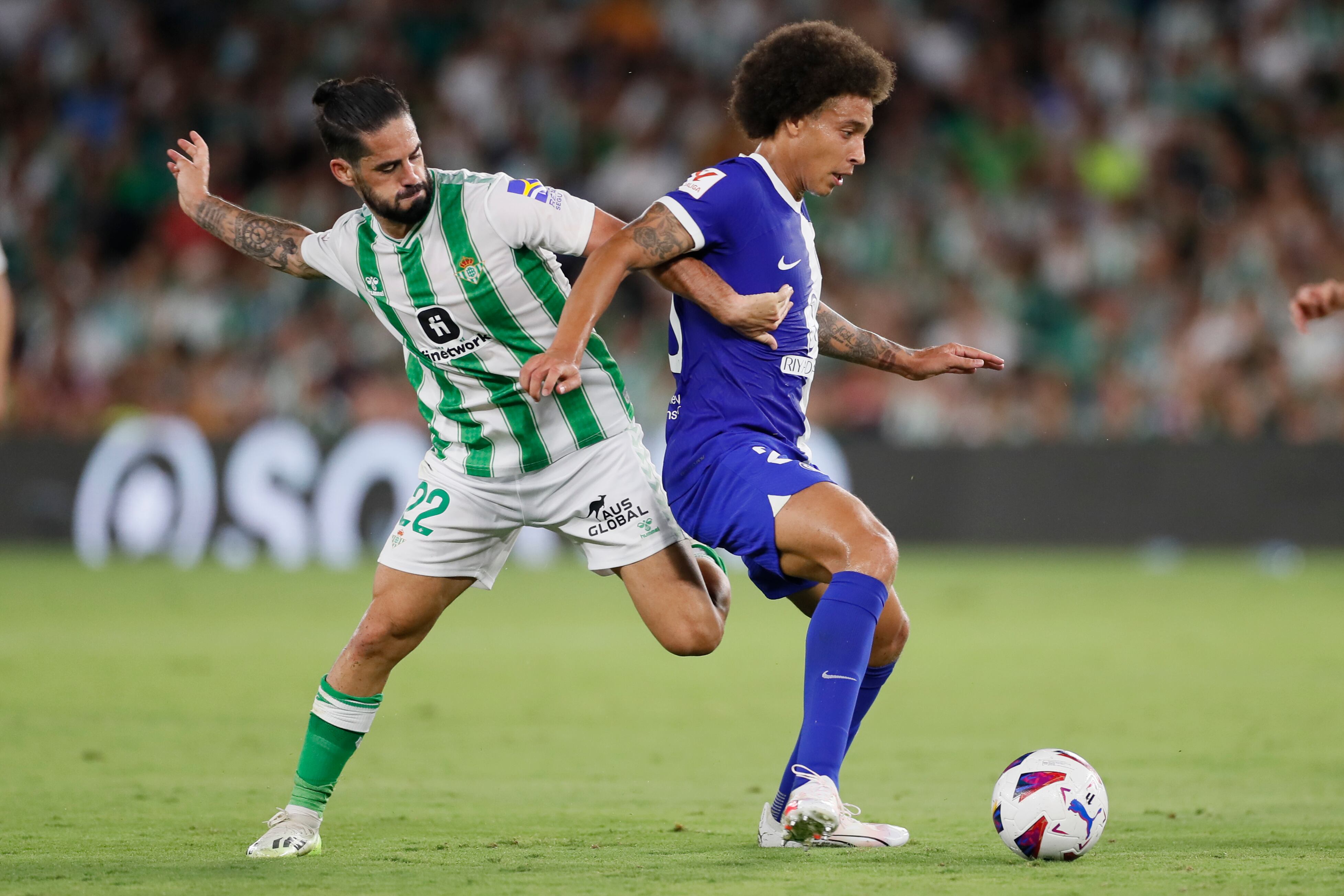 SEVILLA, 20/08/2023.- El centrocampista del Betis Isco (i), disputa una posesión ante Axel Witsel, centrocampista belga del Atlético de Madrid, durante el partido de la segunda jornada de LaLiga que disputan este domingo el Real Betis y el Atlético de Madrid en el estadio Benito Villamarín, en Sevilla. EFE/José Manuel Vidal