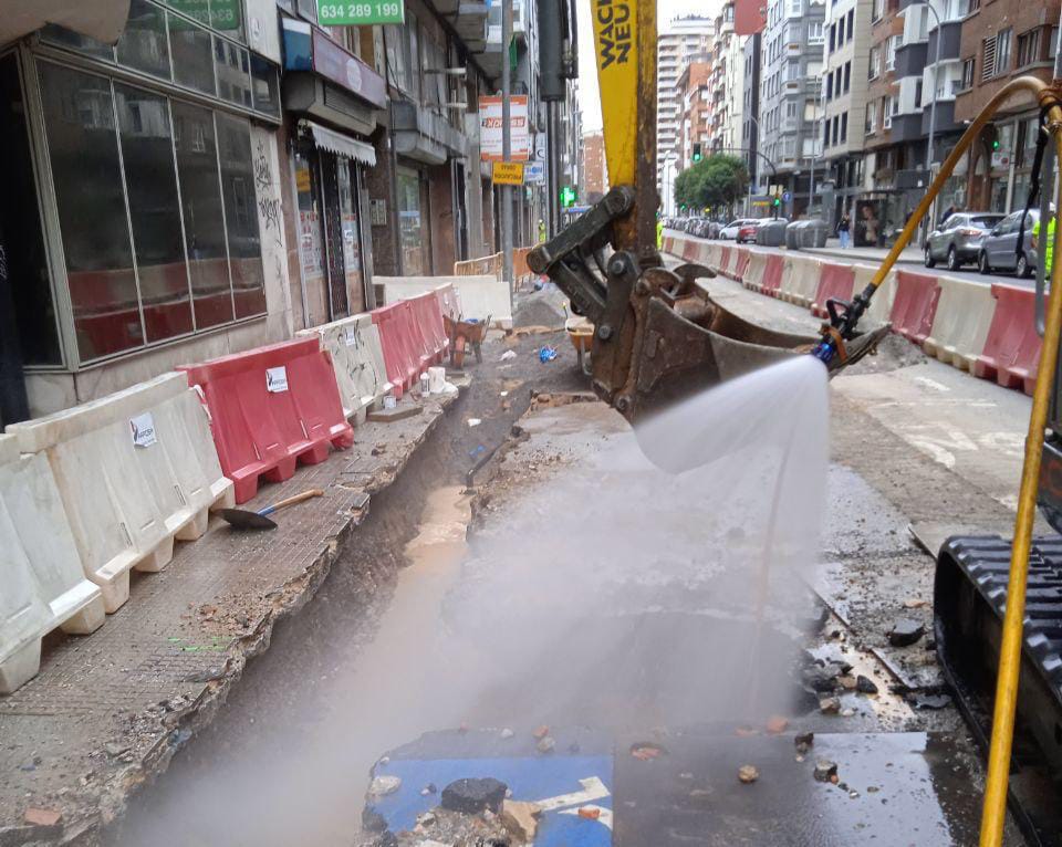Los bomberos de Gijón abaten con agua la nube de gas provocada por la perforación de una tubería en las obras de la Avenida de Pablo Iglesias.