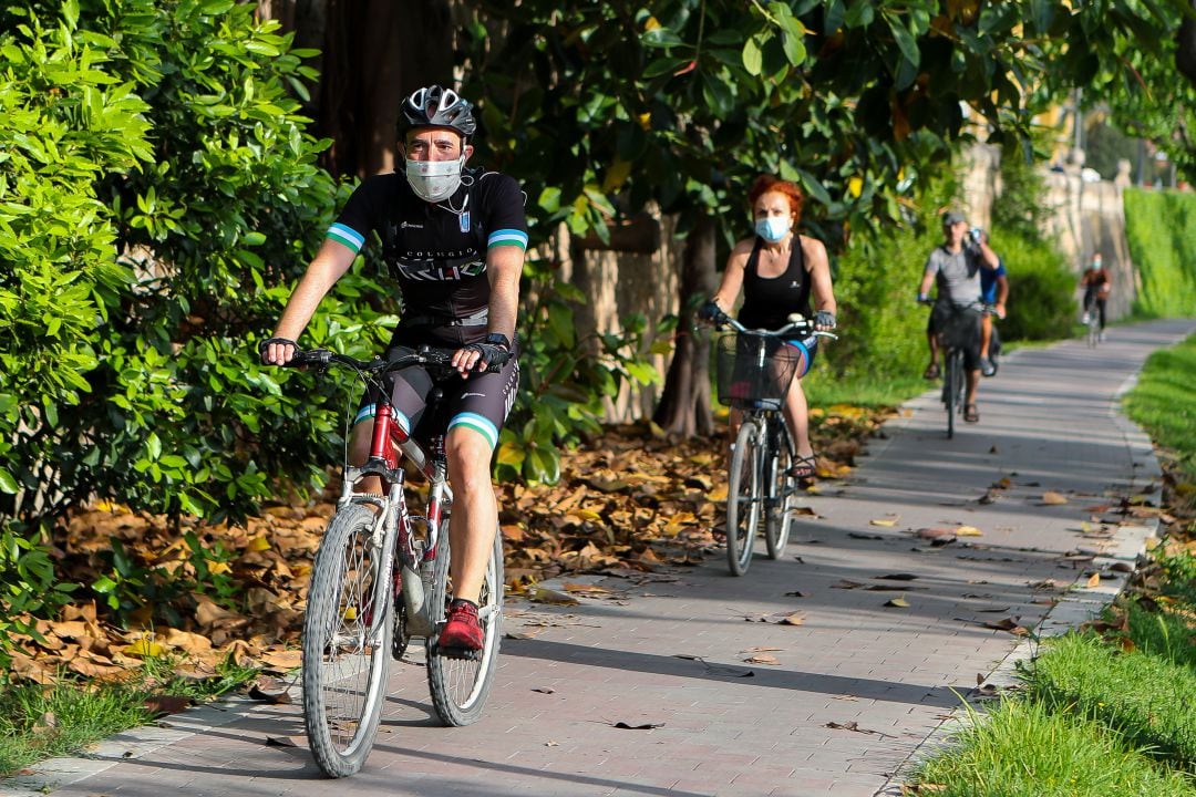 Tres ciclistas circulan por el parque del Túria en la ciudad de València