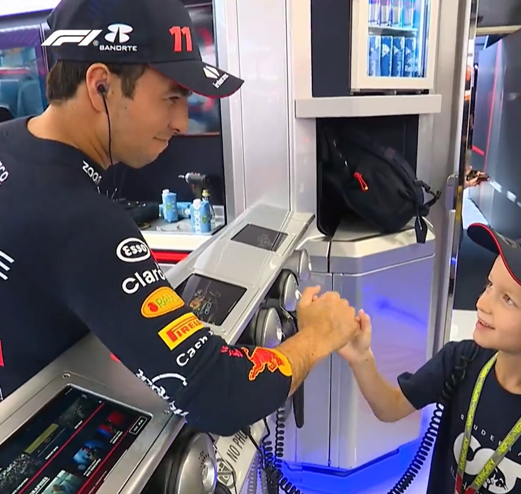 Checo Pérez haciendo feliz a un joven aficionado al piloto mejicano